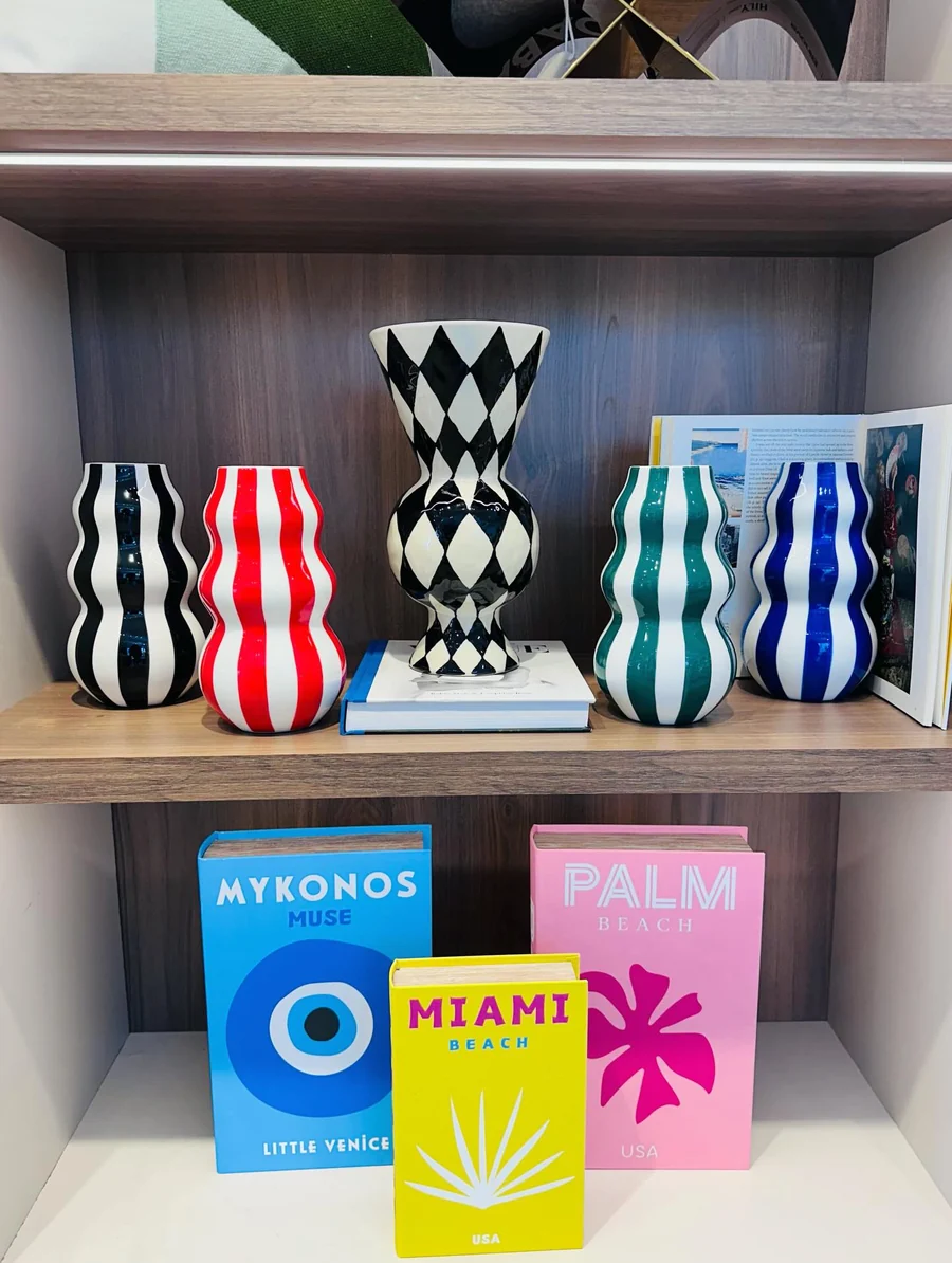 Jarrones de colores y libros en la estantería del showroom